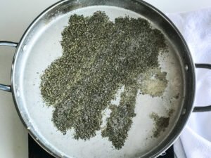 seasoning and milk mixed into the roux in a pan