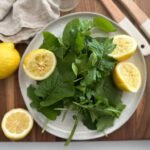 arugula salad with sliced lemons on a plate