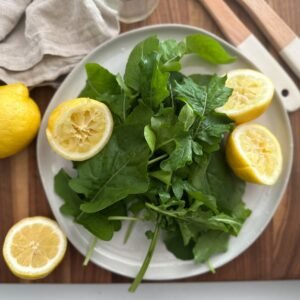arugula salad with sliced lemons on a plate