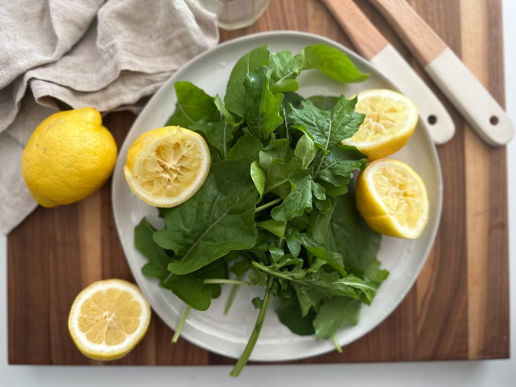 arugula salad with sliced lemons on a plate