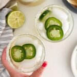 margaritas in glasses with jalapeño garnish