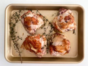 Prepared chicken thighs on a sheet pan
