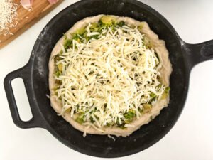 Adding the Fontina Cheese to the pizza.