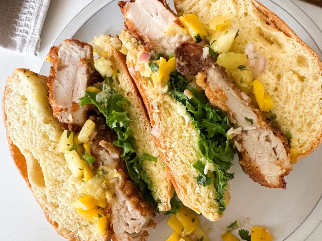 Fried chicken sandwich cut with middle view showing the salsa