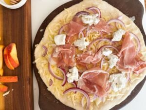 Pizza toppings, purple onion, goat cheese and prosciutto