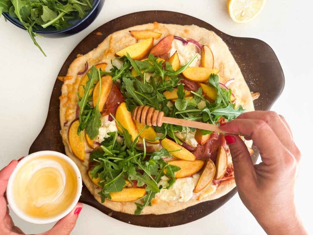 Drizzling honey over the pizza 