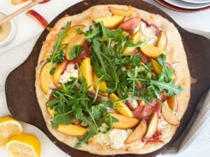 Topped pizza from fresh arugula, honey and lemon.