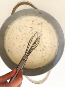 Whisking the white sauce.