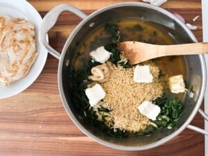 Adding in all of the spinach dip orzo ingredients