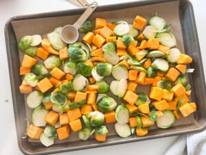 Butternut Squash and Brussel Sprouts on a sheet pan tossed in salt, pure maple syrup and olive oil